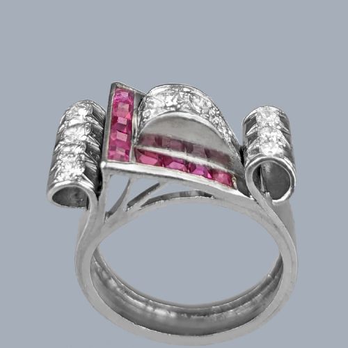 fig 5. A platinum Art Deco buckle ring featuring channel-set red rubies and pave-set old cut diamonds forming a curved scroll motif.
