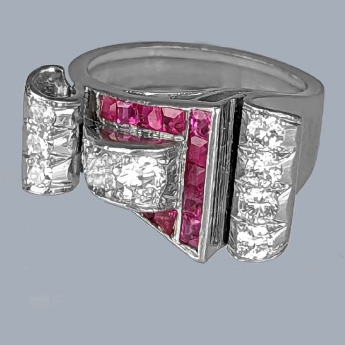 fig 7. A platinum Art Deco buckle ring featuring channel-set red rubies and pave-set old cut diamonds forming a curved scroll motif.