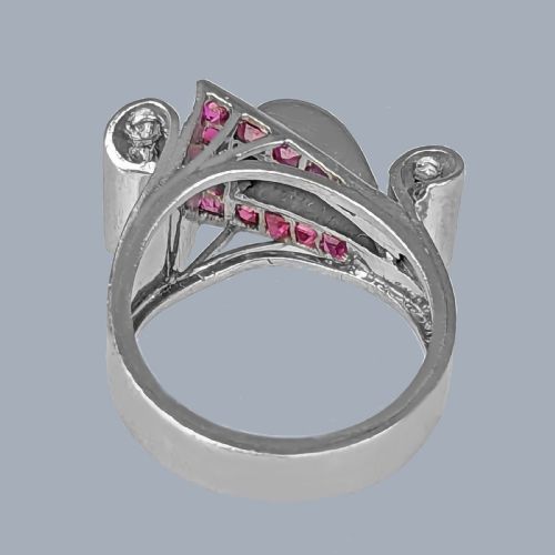 fig 9. A platinum Art Deco buckle ring featuring channel-set red rubies and pave-set old cut diamonds forming a curved scroll motif.
