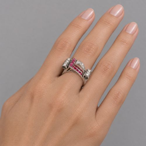 fig 10. A platinum Art Deco buckle ring featuring channel-set red rubies and pave-set old cut diamonds forming a curved scroll motif.