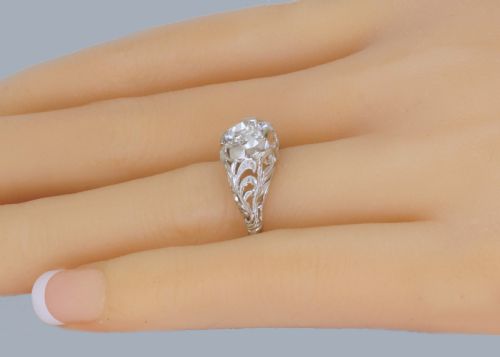 fig 2. An Edwardian platinum engagement ring featuring a central round old cut diamond flanked by detailed filigree shoulders.