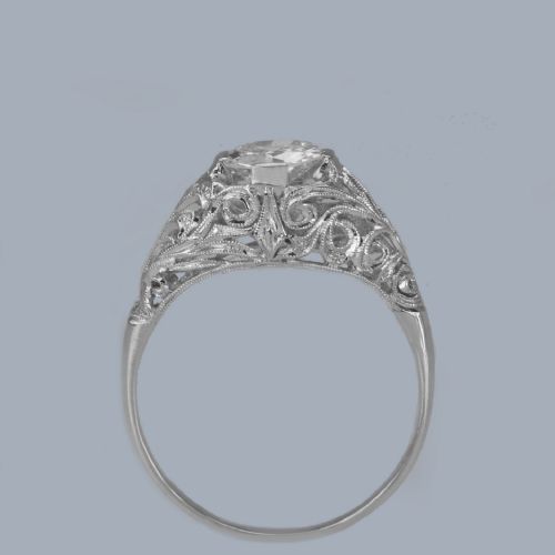 fig 3. An Edwardian platinum engagement ring featuring a central round old cut diamond flanked by detailed filigree shoulders.
