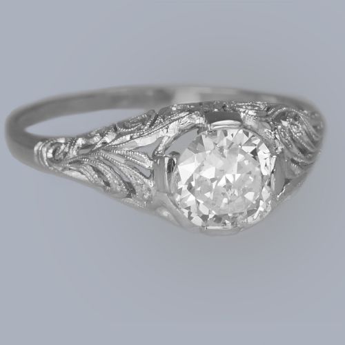 fig 4. An Edwardian platinum engagement ring featuring a central round old cut diamond flanked by detailed filigree shoulders.