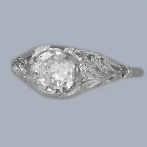 fig 5. An Edwardian platinum engagement ring featuring a central round old cut diamond flanked by detailed filigree shoulders.