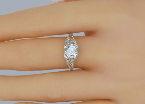 fig 7. An Edwardian platinum engagement ring featuring a central round old cut diamond flanked by detailed filigree shoulders.
