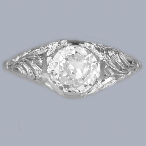 fig 8. An Edwardian platinum engagement ring featuring a central round old cut diamond flanked by detailed filigree shoulders.