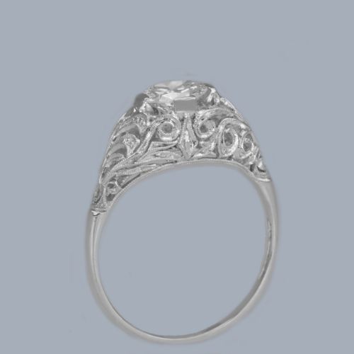 fig 9. An Edwardian platinum engagement ring featuring a central round old cut diamond flanked by detailed filigree shoulders.