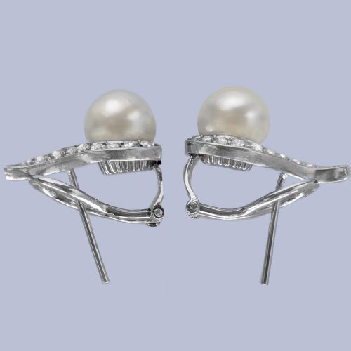 fig 5. A pair of 18ct white gold stud earrings featuring round cream pearls accented with sweeping bands of grain-set diamonds.
