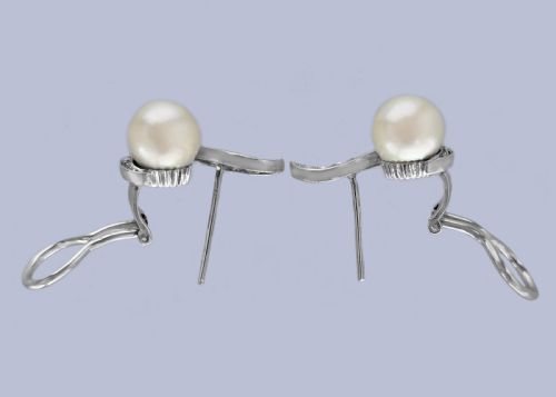 fig 6. A pair of 18ct white gold stud earrings featuring round cream pearls accented with sweeping bands of grain-set diamonds.