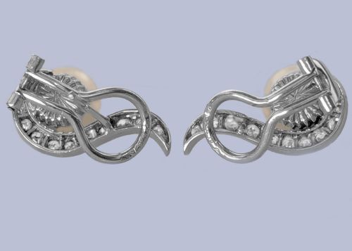 fig 7. A pair of 18ct white gold stud earrings featuring round cream pearls accented with sweeping bands of grain-set diamonds.