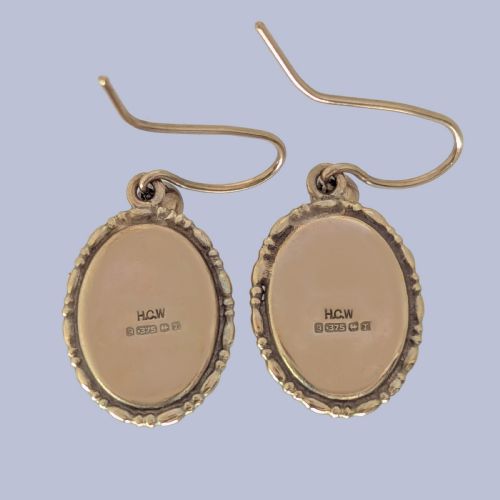 fig 2. Pair of vintage 9ct gold drop earrings featuring oval cabochon purple amethysts set in decorative gold borders with shepherds hook wires.