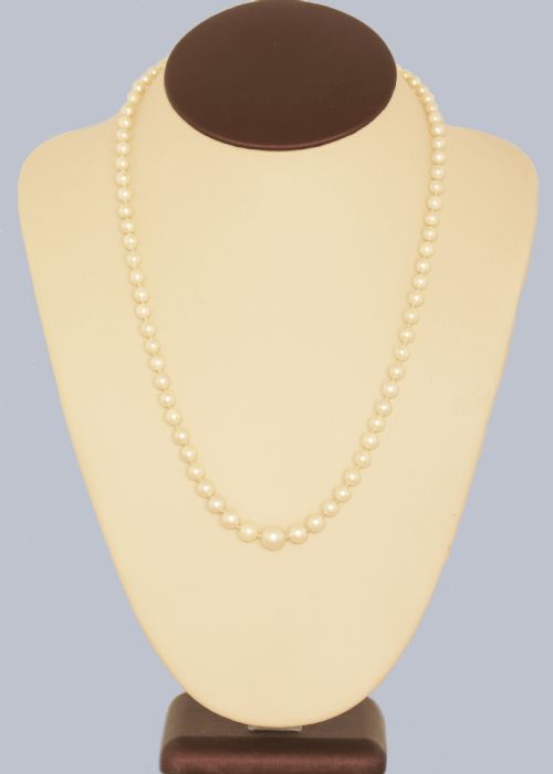fig 1. A single strand of cream cultured pearls featuring an oval purple amethyst mounted in a 9ct gold clasp surrounded by small pearls.