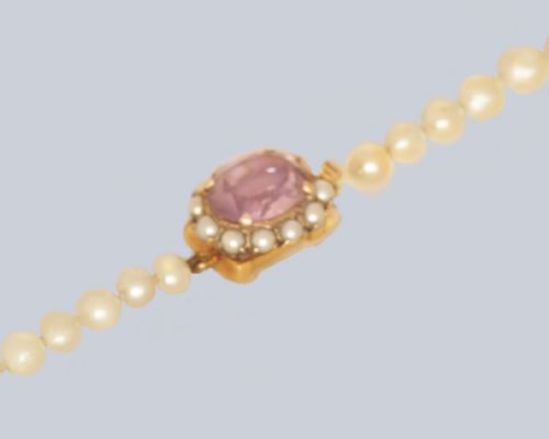 fig 3. A single strand of cream cultured pearls featuring an oval purple amethyst mounted in a 9ct gold clasp surrounded by small pearls.
