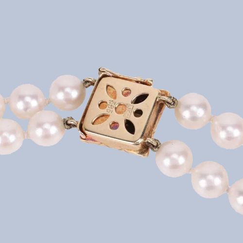 fig 3. A double strand cultured pearl necklace featuring a square textured gold clasp embellished with diamonds.