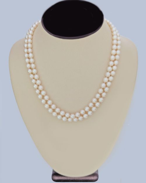 fig 6. A double strand cultured pearl necklace featuring a square textured gold clasp embellished with diamonds.