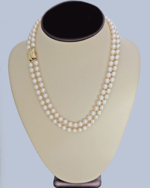 fig 7. A double strand cultured pearl necklace featuring a square textured gold clasp embellished with diamonds.