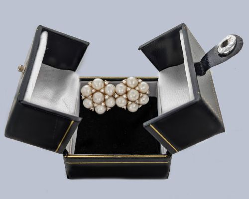fig 5. A pair of 1960s 18ct gold flowerhead cluster earrings set with central and surrounding cream pearls interspersed with diamond accents.