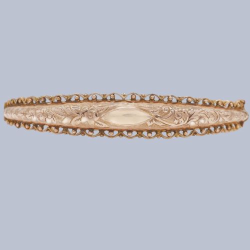 fig 1. An Edwardian 9ct rose gold hinged bangle with foliate engraving, beaded border trim, and a safety chain.