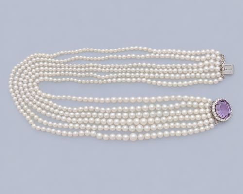 fig 1. A vintage 1950s six-strand cream pearl necklace with an oval purple amethyst clasp framed by diamonds.