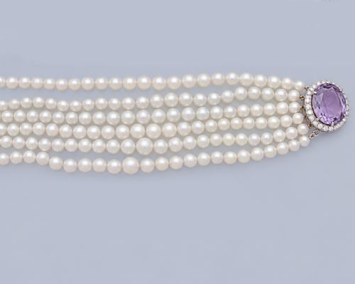 fig 2. A vintage 1950s six-strand cream pearl necklace with an oval purple amethyst clasp framed by diamonds.
