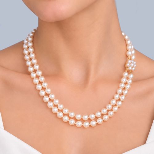 fig 1. A double-strand cultured pearl necklace featuring uniform cream pearls fastened with a floral cluster gold clasp.