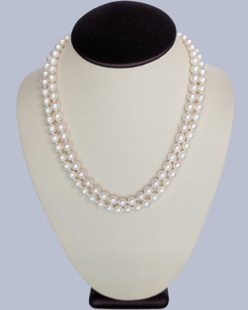 fig 2. A double-strand cultured pearl necklace featuring uniform cream pearls fastened with a floral cluster gold clasp.