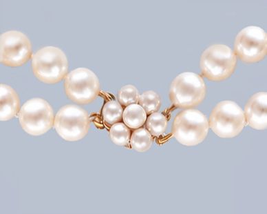 fig 4. A double-strand cultured pearl necklace featuring uniform cream pearls fastened with a floral cluster gold clasp.