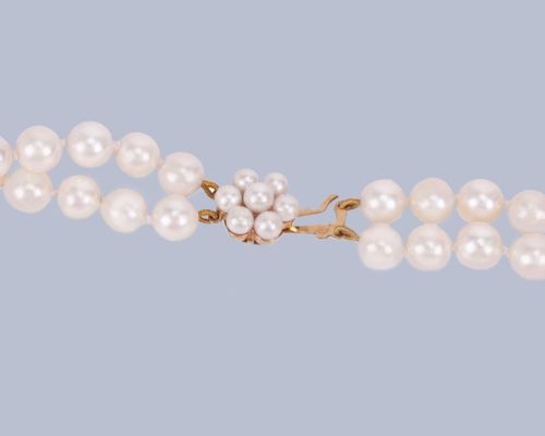 fig 5. A double-strand cultured pearl necklace featuring uniform cream pearls fastened with a floral cluster gold clasp.