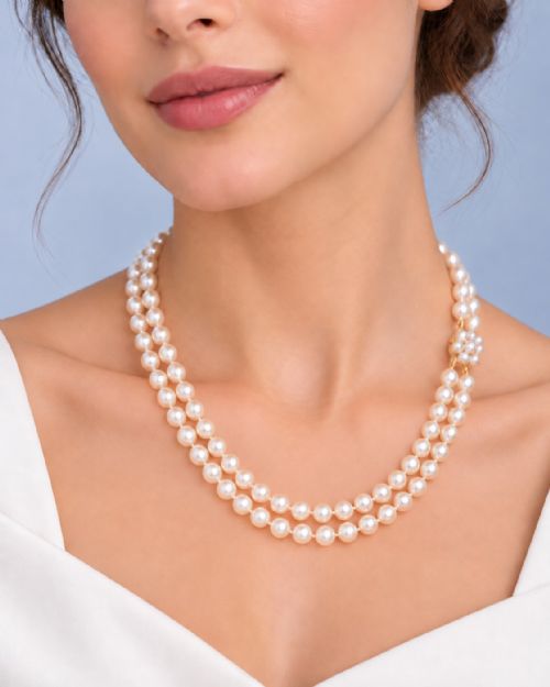fig 7. A double-strand cultured pearl necklace featuring uniform cream pearls fastened with a floral cluster gold clasp.