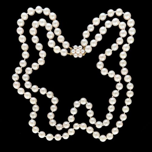 fig 8. A double-strand cultured pearl necklace featuring uniform cream pearls fastened with a floral cluster gold clasp.