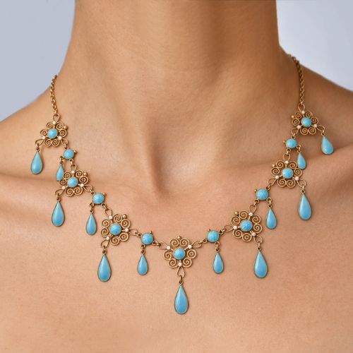 fig 1. An Art Nouveau silver gilt festoon necklace featuring filigree scrollwork, turquoise guilloche enamel discs, and suspended teardrop pendants.