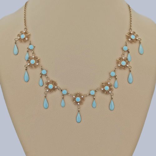 fig 9. An Art Nouveau silver gilt festoon necklace featuring filigree scrollwork, turquoise guilloche enamel discs, and suspended teardrop pendants.