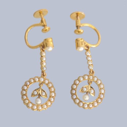 fig 2. A pair of Edwardian 15ct yellow gold drop earrings featuring circular seed pearl frames around foliate central motifs with screw-back fittings.