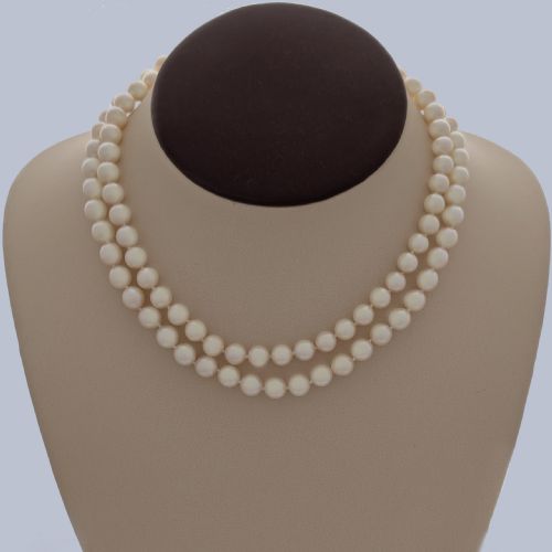 fig 2. A long single strand of creamy white cultured pearls featuring a 9ct gold flower cluster clasp set with a central purple amethyst.