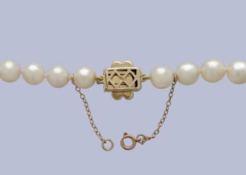 fig 3. A long single strand of creamy white cultured pearls featuring a 9ct gold flower cluster clasp set with a central purple amethyst.