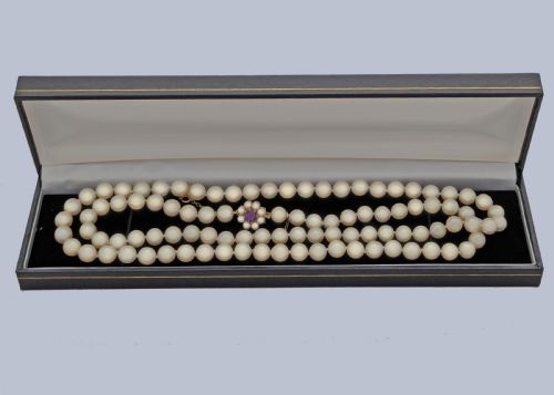 fig 6. A long single strand of creamy white cultured pearls featuring a 9ct gold flower cluster clasp set with a central purple amethyst.