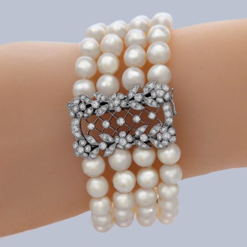 fig 1. An Edwardian four-strand pearl bracelet featuring a central openwork diamond floral clasp in white metal.