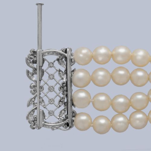 fig 3. An Edwardian four-strand pearl bracelet featuring a central openwork diamond floral clasp in white metal.