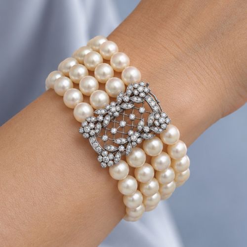 fig 5. An Edwardian four-strand pearl bracelet featuring a central openwork diamond floral clasp in white metal.
