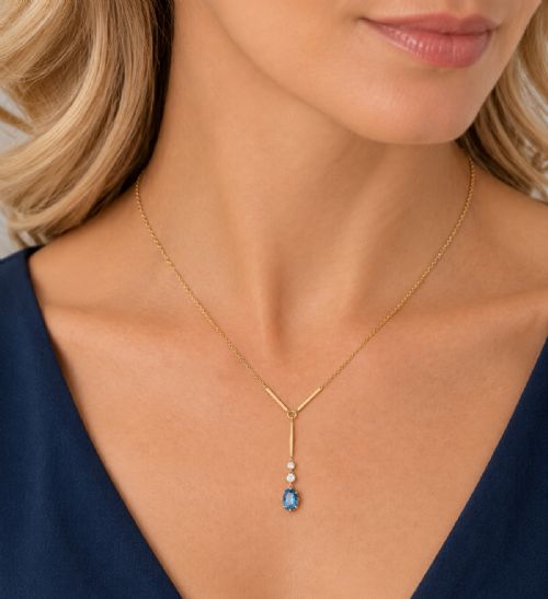 fig 3. An Edwardian 15ct yellow gold lavalier pendant necklace featuring a geometric bar drop, two millegrain-set old cut diamonds, and an oval blue topaz gemstone.