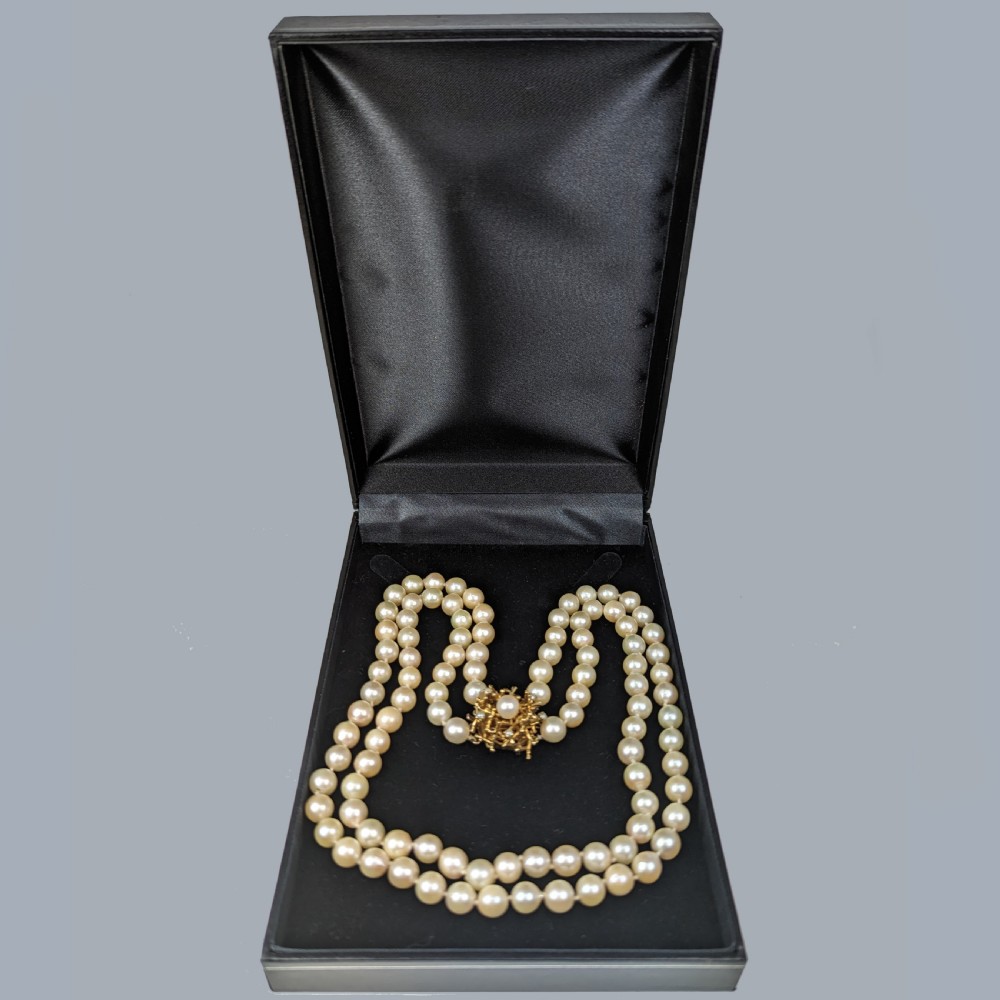 A double strand cream pearl necklace featuring an abstract textured gold centre clasp with a central pearl accent. View XIII