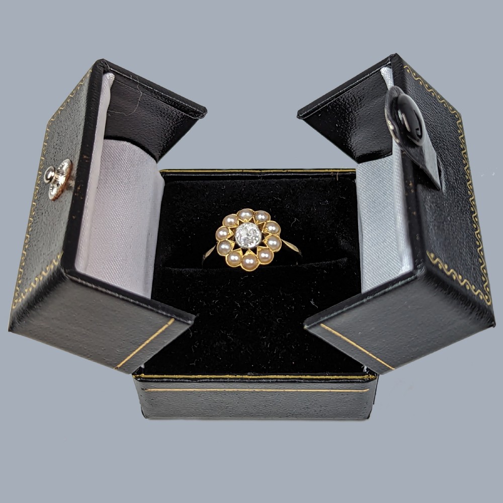 An Edwardian cluster ring featuring a central old-cut diamond surrounded by ten pearls set in 18ct yellow gold and platinum. View VIII