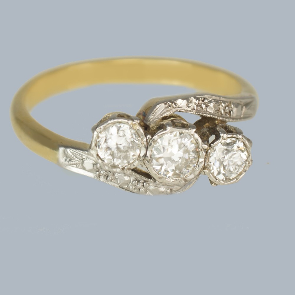 An Edwardian 18ct yellow gold trilogy ring with three round diamonds set diagonally in a platinum twist setting. View III