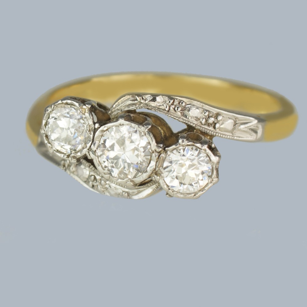 An Edwardian 18ct yellow gold trilogy ring with three round diamonds set diagonally in a platinum twist setting. View IV