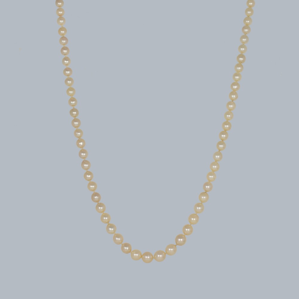 A single strand of cream-coloured pearls fitted with a central clasp set with three old cut diamonds. View III