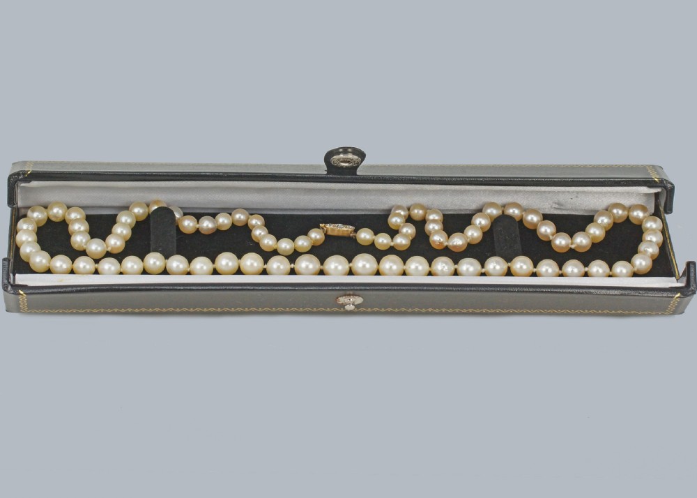 A single strand of cream-coloured pearls fitted with a central clasp set with three old cut diamonds. View VII