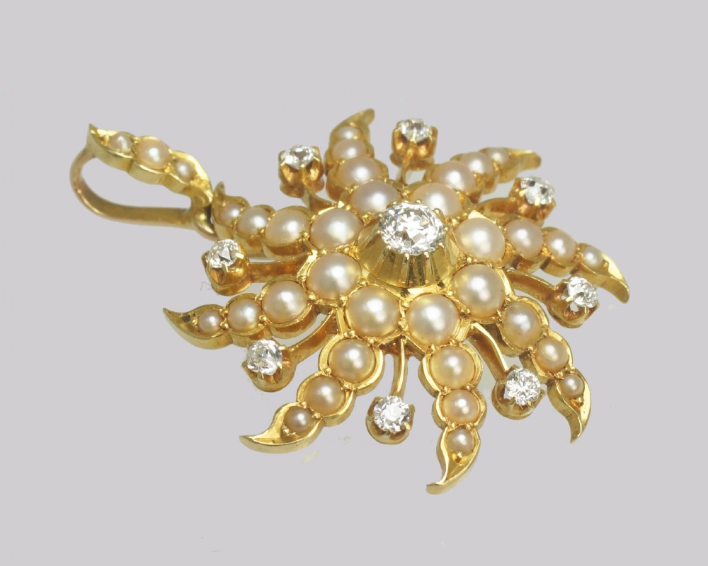 An 18ct yellow gold starburst pendant set with a central old cut diamond and accent diamonds, surrounded by graduated seed pearls along swirling rays. View IV