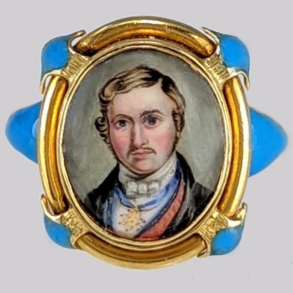 An antique Victorian gold ring featuring an oval hand-painted portrait miniature of a gentleman framed with blue enamel accents. View VII