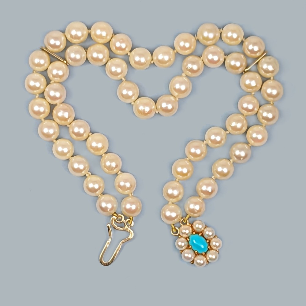 A vintage double strand pearl bracelet featuring cream pearls connected by a 9ct yellow gold clasp with a central turquoise stone surrounded by seed pearls. View V