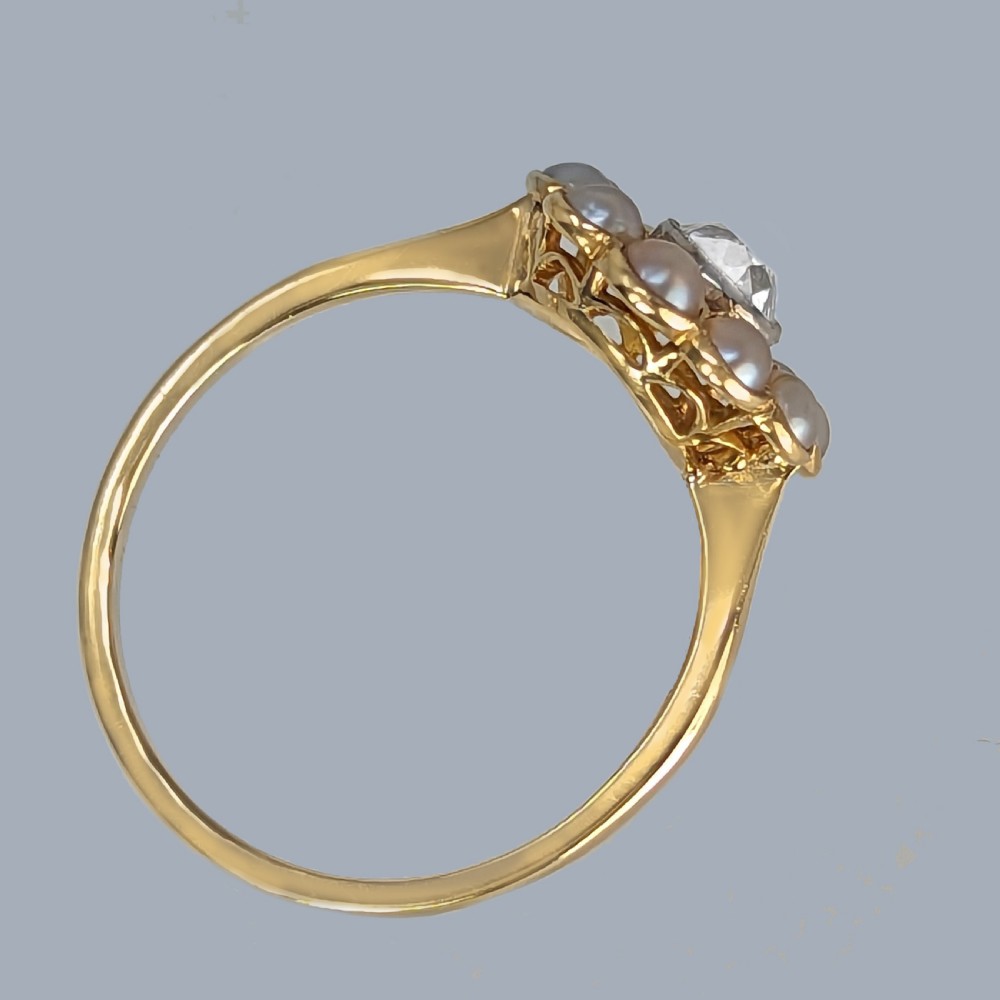 An antique Edwardian cluster ring featuring a central round diamond encircled by ten pearls set in 18ct yellow gold and platinum. View VII